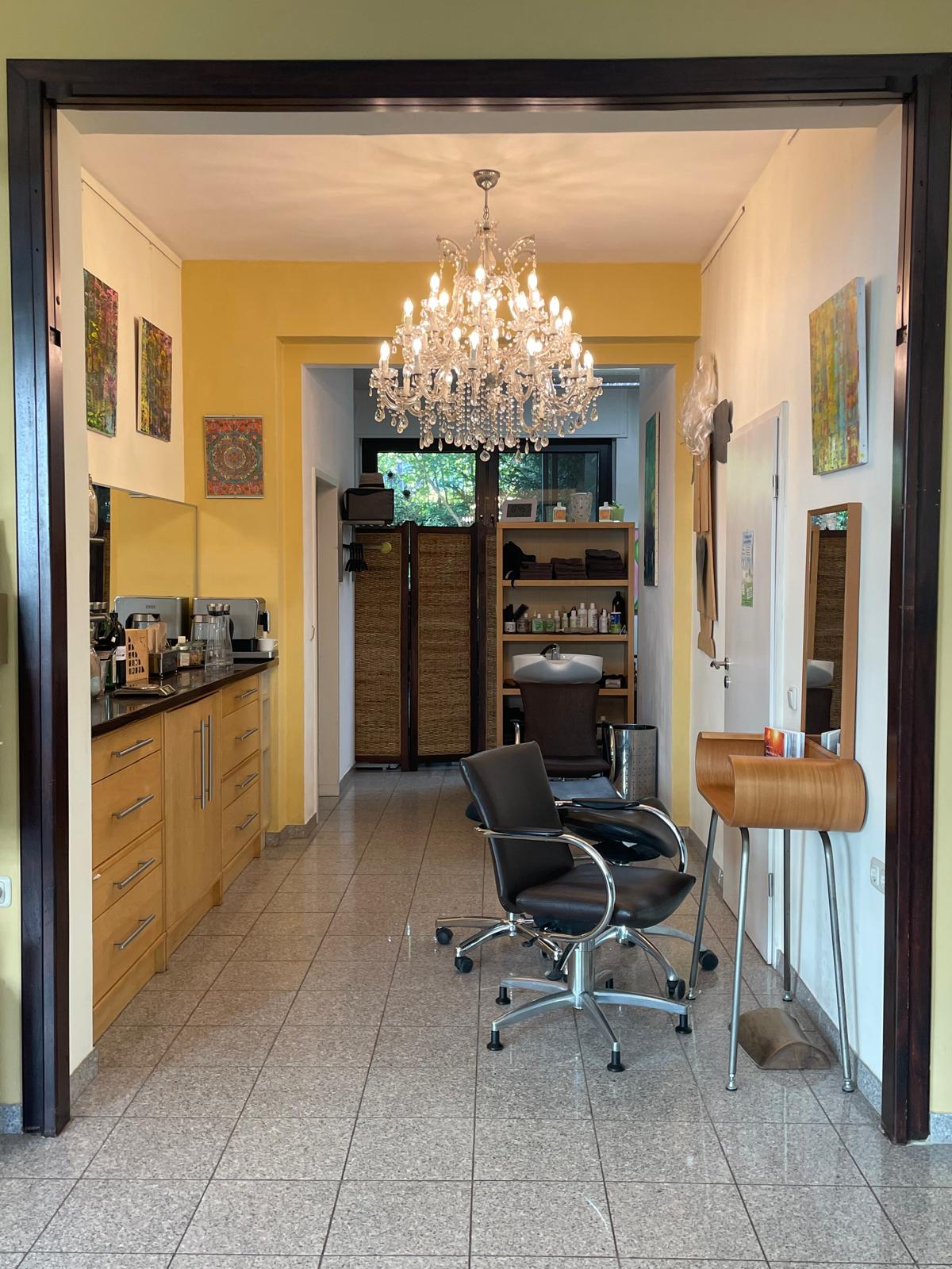 Blick in die Haargalerie Aachen mit Kristalllüster, Kunst und warmen Farben